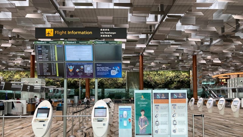 Spacious airport lobby featuring flight information displays and self-check-in kiosks., tags: chioschi di - pexel